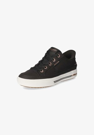 Baskets basses Skechers noires avec semelle blanche, lacets noirs et œillets ainsi que détails de marque en or rose.