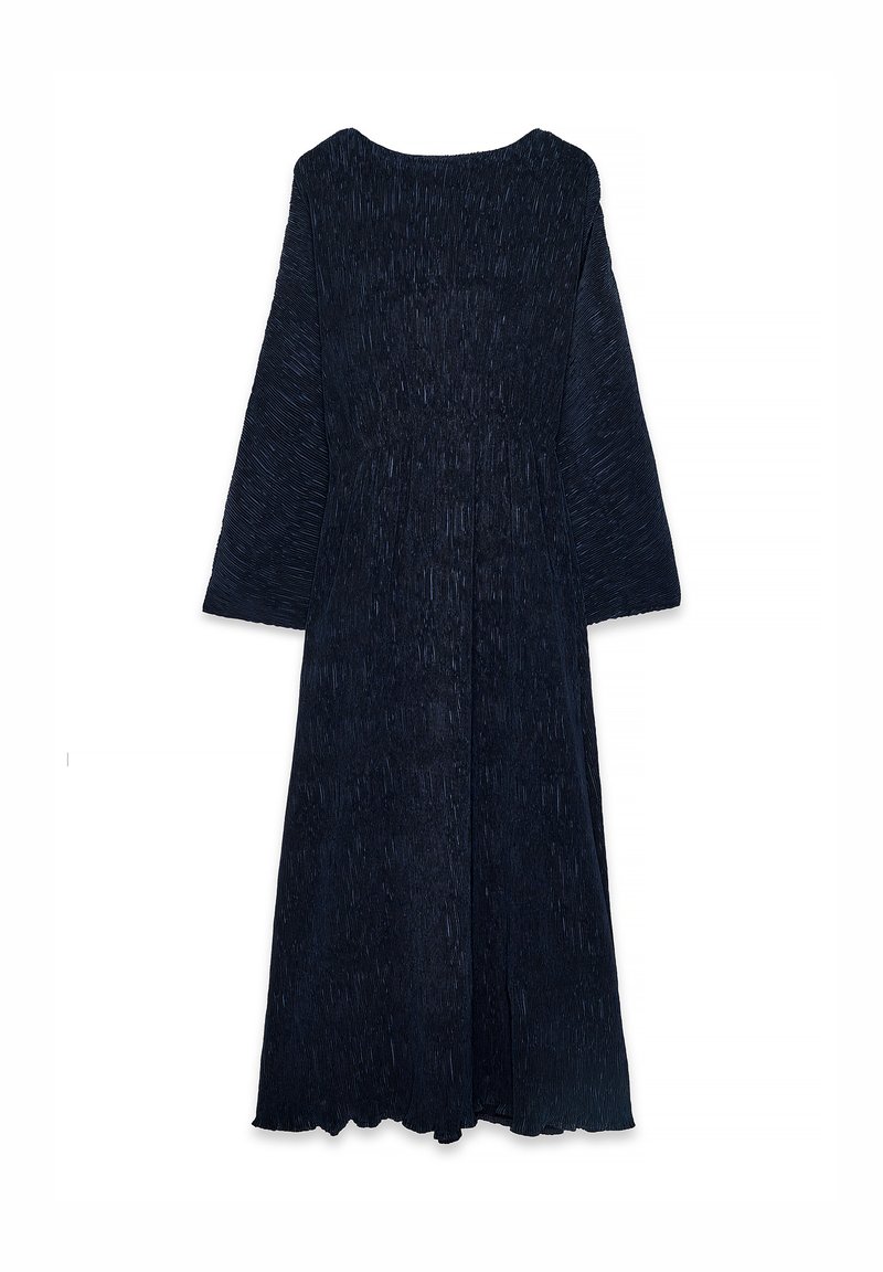 Long-sleeve, floor-length dress in dark navy with pleated texture and a scalloped hem. Made from soft, lightweight fabric.