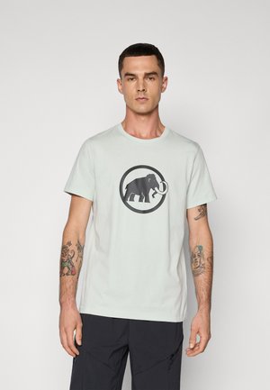 Licht mintgroene katoenen t-shirt met een grote zwarte mammoet grafiek in een cirkelvormige omtrek, met een ronde hals en korte mouwen.