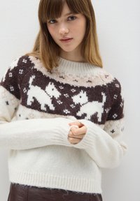 Weißer Strickpullover mit einem braunen und cremefarbenen Design, das weiße Hundesilhouetten und geometrische Muster zeigt, mit langen Ärmeln und gerippten Bündchen.