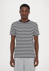 Fekete-fehér csíkos póló, kerek nyakkivágással, rövid ujjakkal és slim fit szabással. Sima anyag és egyenletes csíkos minta.