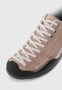 Hellbrauner Wildlederschuh zum Klettern mit weißen Schnürsenkeln, schwarzem Gummikappenschutz an der Zehe und SCARPA-Logo an der Seite, sowie einem strukturierten Mesh-Kragen für zusätzlichen Komfort.