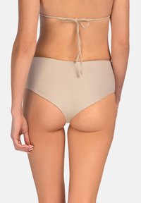 Beżowe bikini z wysokim stanem i minimalnym zakryciem z tyłu. Gładka faktura, z cienkimi sznurkami z tyłu.