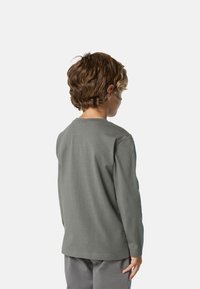 Camisa de algodón gris de manga larga con cuello redondo, que muestra una textura suave, corte regular y dobladillo cosido. Esta es la vista trasera.