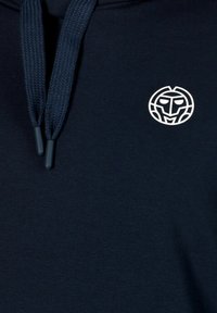 Felpa con cappuccio di colore navale con un logo bianco rotondo sul petto e lacci blu scuro con punte di plastica. Tessuto morbido e liscio.