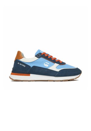 Freizeitschuh aus blauem Stoff, marineblauen Velours-Overlays, weißen Akzenten, orangen Schnürsenkeln und braunem Fersendetail auf einer weißen Sohle mit hellbraunem Profil.