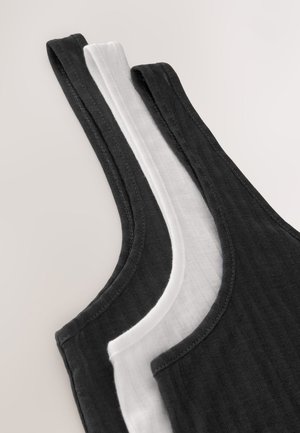 Trois débardeurs en noir et blanc, présentant une texture côtelée, des bretelles larges et des ourlets doucement arrondis. Coutures apparentes nettes.