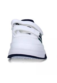 White athletic shoe with navy accents, featuring a smooth, synthetic upper, a padded collar, and two adjustable Velcro straps.