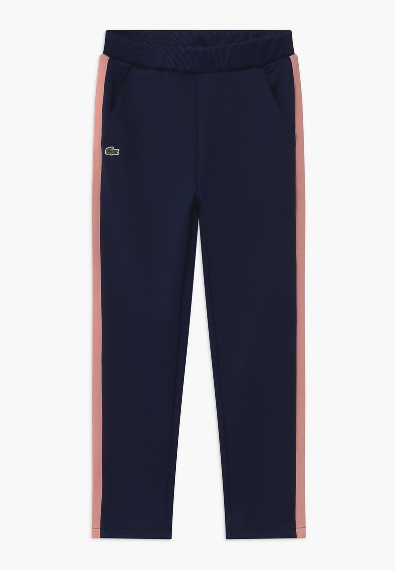 Pantalon de sport bleu marine avec des bandes latérales roses, une ceinture élastique, des poches latérales et un petit logo crocodile vert sur la cuisse gauche.