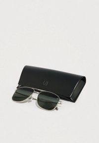Gafas de sol con lentes de color verde oscuro y montura de metal plateado. Incluye un elegante estuche negro con un logotipo.