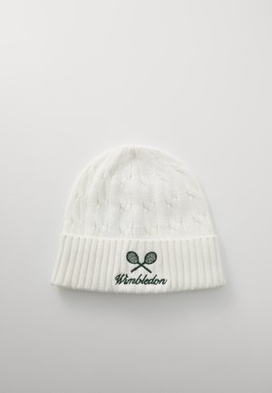 Bonnet tricoté blanc avec un motif en câble, un poignet côtelé et un logo "Wimbledon" brodé en vert avec des raquettes de tennis croisées.