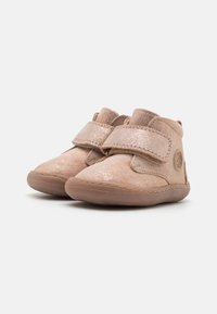 Botas de ante rosa para toddlers con un brillo metálico, que cuentan con correas ajustables y una suela de goma texturizada. Puntera redonda y acentos cosidos.