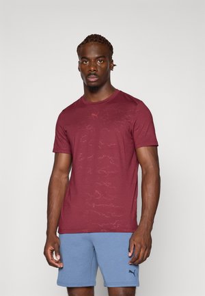 Bordeauxkleurig sport t-shirt met een subtiel patroon, ronde hals, korte mouwen, gemaakt van lichtgewicht stof. Logo in een contrasterende kleur aan de voorkant.