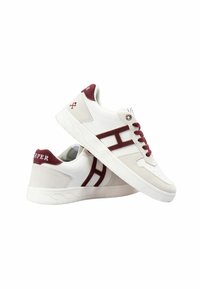 Białe sneakersy z burgundowymi akcentami, z zamszową i skórzaną cholewką, perforowanym noskiem oraz detalem logo na pięcie i boku.