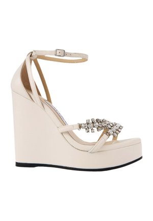 Sandale à talon compensé beige avec bride à la cheville, semelle plateforme et strass décoratifs sur la bride avant.
