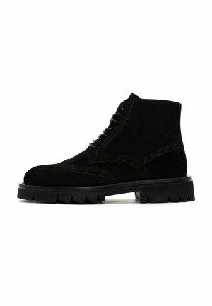 Bottes de cheville en suede noir avec un design à lacets, des coutures décoratives et une semelle en caoutchouc épaisse. Présente un bout rond et des accents texturés.