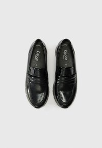 Black leather slip-on shoes with a textured finish, featuring a decorative strap across the instep and a cushioned sole for comfort.