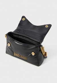 Bolso de cuero negro con herrajes dorados, que presenta un diseño único de orejas de gato, compartimento con cremallera y logo embosado en la parte frontal.