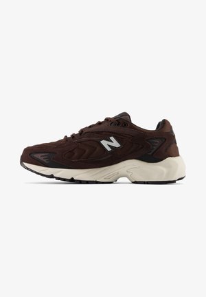 Ciemnobrązowy sneaker New Balance z siateczkową i zamszową cholewką, białą wyściełaną podeszwą i czarnym spodem, widziany z boku.