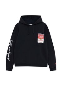 Sweat à capuche noir avec illustration d'une boîte de soupe à la tomate Campbell's sur la poitrine et texte blanc en cursive sur la manche droite.
