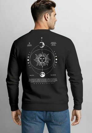 Black sweatshirt featuring a white graphic of the sun and moon with celestial symbols and text on the back, ribbed cuffs, and crew neck.