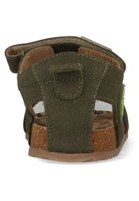 Groene leren kindersandaal met kurken voetbed, verstelbare riem en uitsnijdingen bij de hiel voor ventilatie.