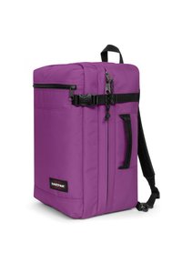Mochila morada de forma rectangular, hecha de un tejido duradero. Cuenta con una asa superior, cremalleras negras y correas ajustables. La parte frontal tiene un parche con el logo.