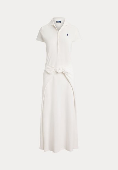 Fehér rövid ujjú polo ruha gombos gallérral, deréknál kötött szövetdísszel és kis tengerészkék hímzett logóval a mellkason.