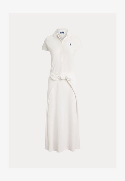 Fehér rövid ujjú polo ruha gombos gallérral, deréknál kötött szövetdísszel és kis tengerészkék hímzett logóval a mellkason.