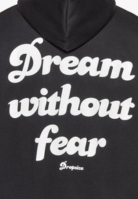 Schwarzer Hoodie mit kräftigem weißen Text, der "Trau dich zu träumen, ohne Angst" liest, und einem kleineren "Dropsize"-Logo am unteren Ende. Weicher Stoff.