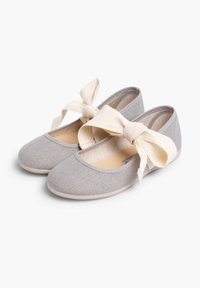 Bailarinas de tela gris con punta redonda, suela suave y lazos de tela beige en el tobillo. Material texturizado con forro interior suave.