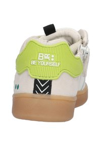Heren sneakers met een witte en beige suède bovenkant, groene rubberen hieltab, zwarte accenten en een gumrubberen zool. Bevat een "WEES JEZELF" ontwerp.
