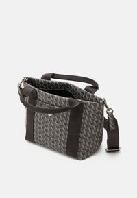 Sac fourre-tout de taille moyenne avec un motif géométrique, deux poignées courtes et une bandoulière amovible et réglable en tissu foncé.