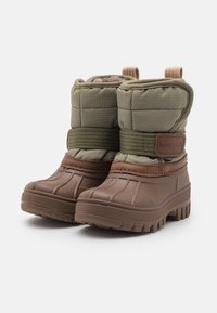 Pár hnědých a olivových zimních bot pro batolata se silnými podrážkami, prošívaným svrškem a suchým zipem označeným "bisgaard" na bílém pozadí.