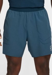 Men's shorts in dark blue, made of lightweight material. Features elastic waistband, side pockets, and a white logo on the hem.