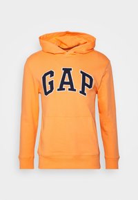 Sudadera con capucha naranja de tela suave, con bolsillo tipo canguro en la parte delantera y un gran logo "GAP" en azul marino estampado en el pecho.