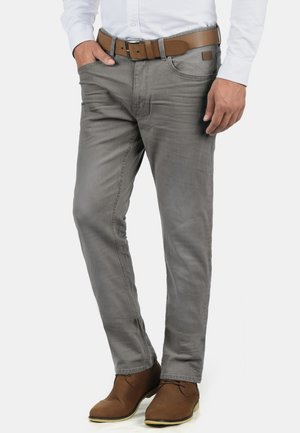 Grå denimbukser med slim fit, med en ensfarvet design, frontlommer og et brunt læderbælte. Sammen med brune ankelstøvler.