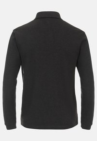 Schwarz langärmliges Polohemd aus weichem Stoff, mit einem kragenförmigen Hals und seitlichen Schlitzen für mehr Komfort, mit einer glatten, gleichmäßigen Textur.