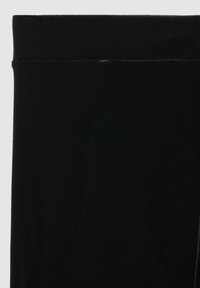 Leggings in velluto nero con una texture liscia e una vita alta. Il tessuto presenta una leggera lucentezza, con dettagli di cucitura puliti.