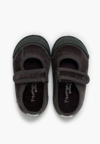 Schwarze Veloursleder-Kleinkinderschuhe mit Klettverschluss und Gummisohlen. Verfügen über ein weiches Innenfutter und kreisförmige strukturierte Akzente an der Sohle.