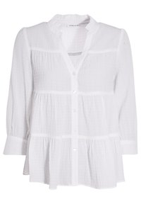 Blouse en tissu blanc froissé avec manches longues, col à volants et fermeture boutonnée sur le devant. Présente des panneaux horizontaux et un ourlet évasé.