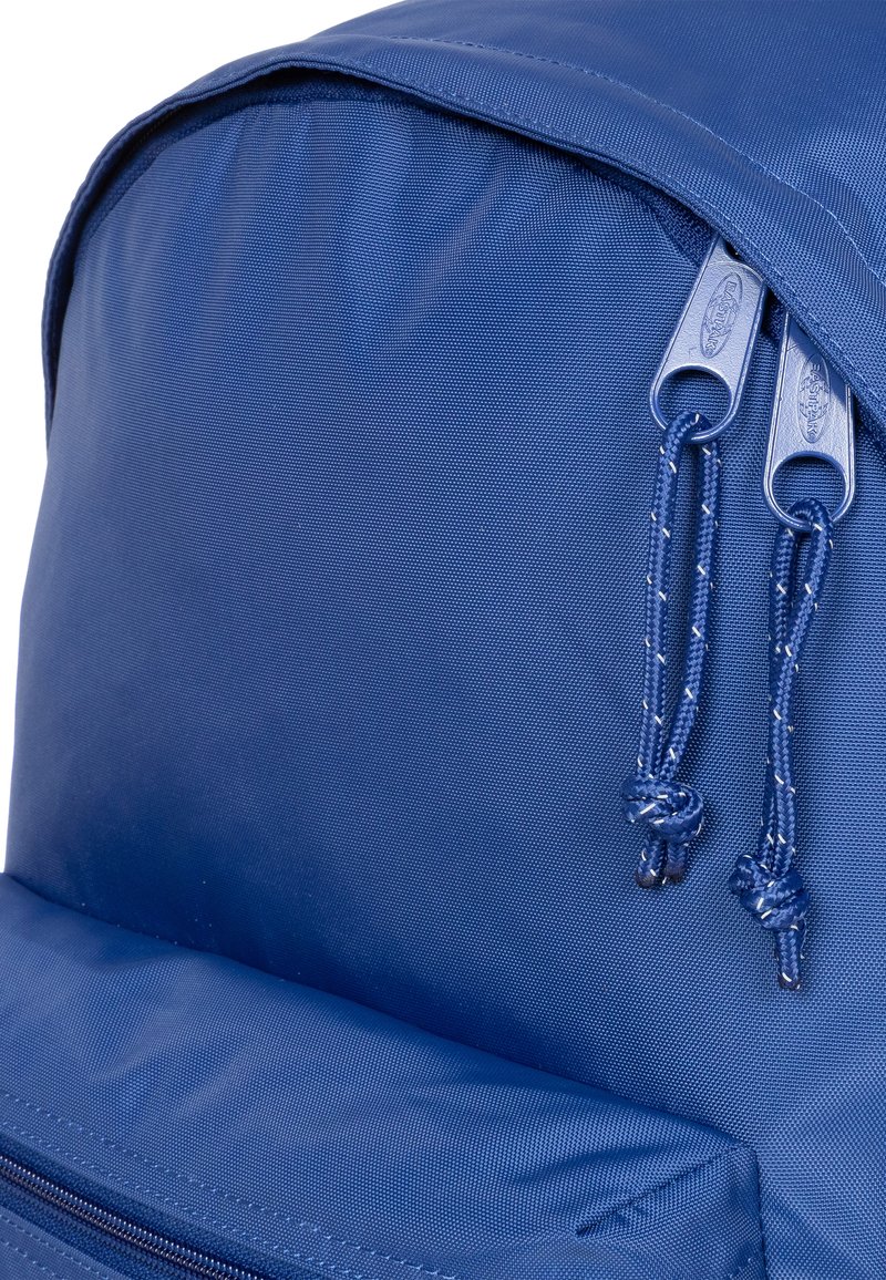 Mochila azul marino con un exterior de nylon texturizado, que cuenta con dos cremalleras resistentes y cordones trenzados para facilitar la apertura.