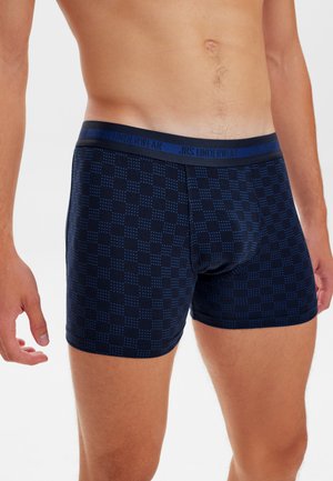 Blå mønstrede bokserboksere med en blød elastisk talje, mærket "JBS UNDERWEAR." Materialet virker åndbart med en tæt pasform.