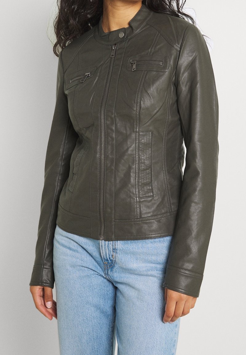 Ciemnozielona skórzana kurtka o dopasowanym kroju, z zapinanymi na zamek kieszeniami na piersi i szczegółowo wykończonymi szwami. Posiada stójkę i długie rękawy.