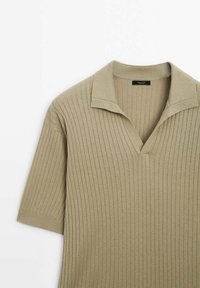 Pull beige côtelé à manches courtes avec un large col et un décolleté en V, fabriqué en tissu tricoté doux.