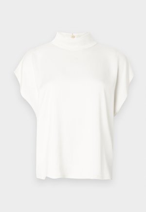 Haut blanc à manches courtes avec un col montant, fabriqué en tissu doux. Doté d'un détail de bouton à l'arrière du col. Silhouette simple et décontractée.