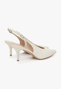 Bílé lodičky na úzkém podpatku s špičatou špičkou, hladký kožený svršek a 7,5 cm vysoký jehlový podpatek. Obsahuje boční přezku pro úpravu.
