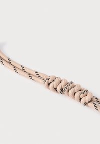 Corde tressée beige avec une surface texturée, présentant un nœud serré. Des rayures diagonales noires courent le long de sa longueur.