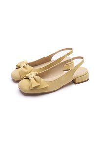 Žute sandale od brušene kože s remenom oko pete, zaobljenim vrhom, velikom mašnom sprijeda i niskom blok petom. Glatka unutarnja podstava.