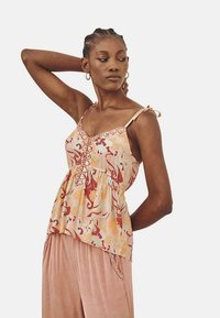 Top sin mangas, ligero, con estampado floral en tonos naranja pastel, beige y rojo, con cintura fruncida y tirantes ajustables.